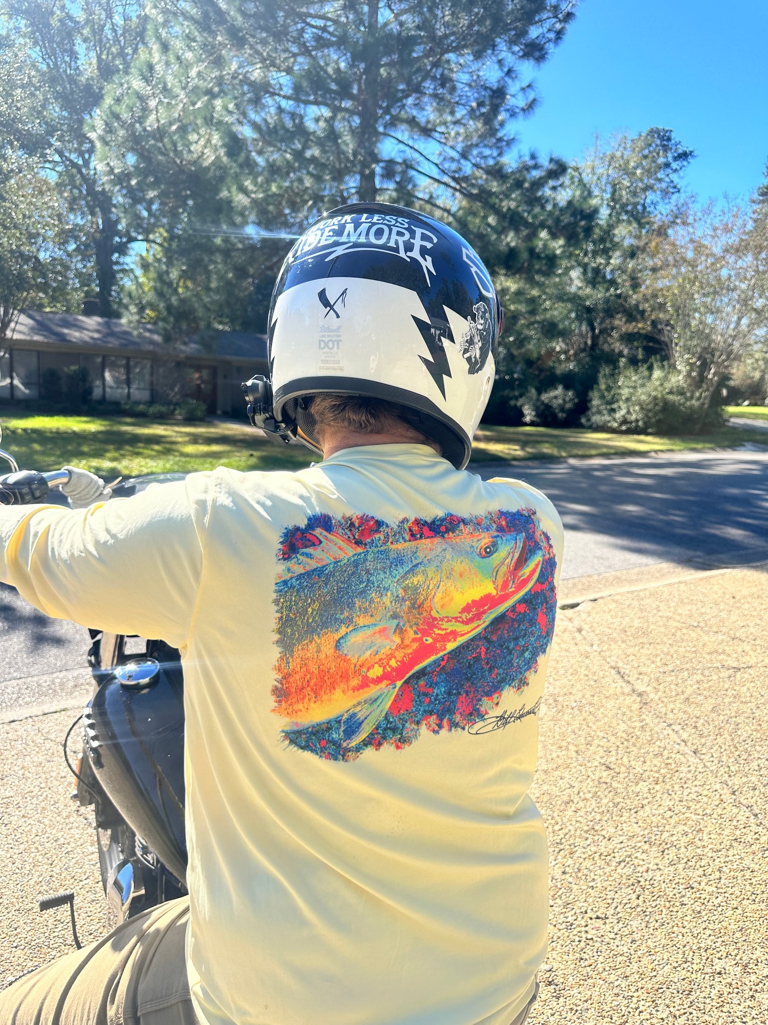 Motorcyclist wearing Speckled Trout UPF 50+ Fishing Shirt with bold trout artwork, combining casual style with sun protection.