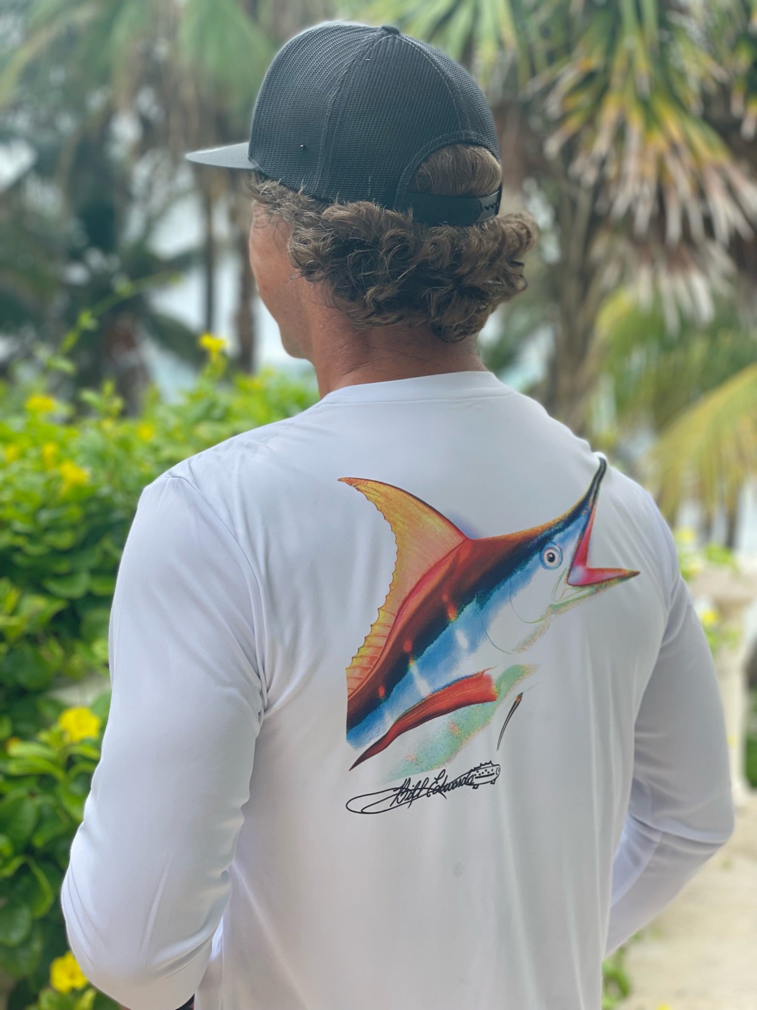 Back view of man wearing Marlin Performance Fishing Shirt with UPF 50 sun protection featuring colorful marlin artwork by Bill Edwards.
