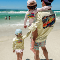 Family at the beach wearing matching Mr. Turtlehead Performance Fishing Shirts with sea turtle graphics, highlighting kids' UPF 50+ sun protection.
