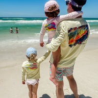 Father and daughters in matching Speckled Trout UPF 50+ Fishing Shirts at the beach, emphasizing family sun protection and stylish fishing apparel.