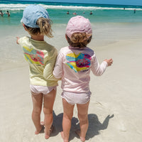 Two toddlers wearing Mr. Turtlehead Kids Performance Fishing Shirts with sea turtle design at the beach, showcasing UPF 50+ sun protection.