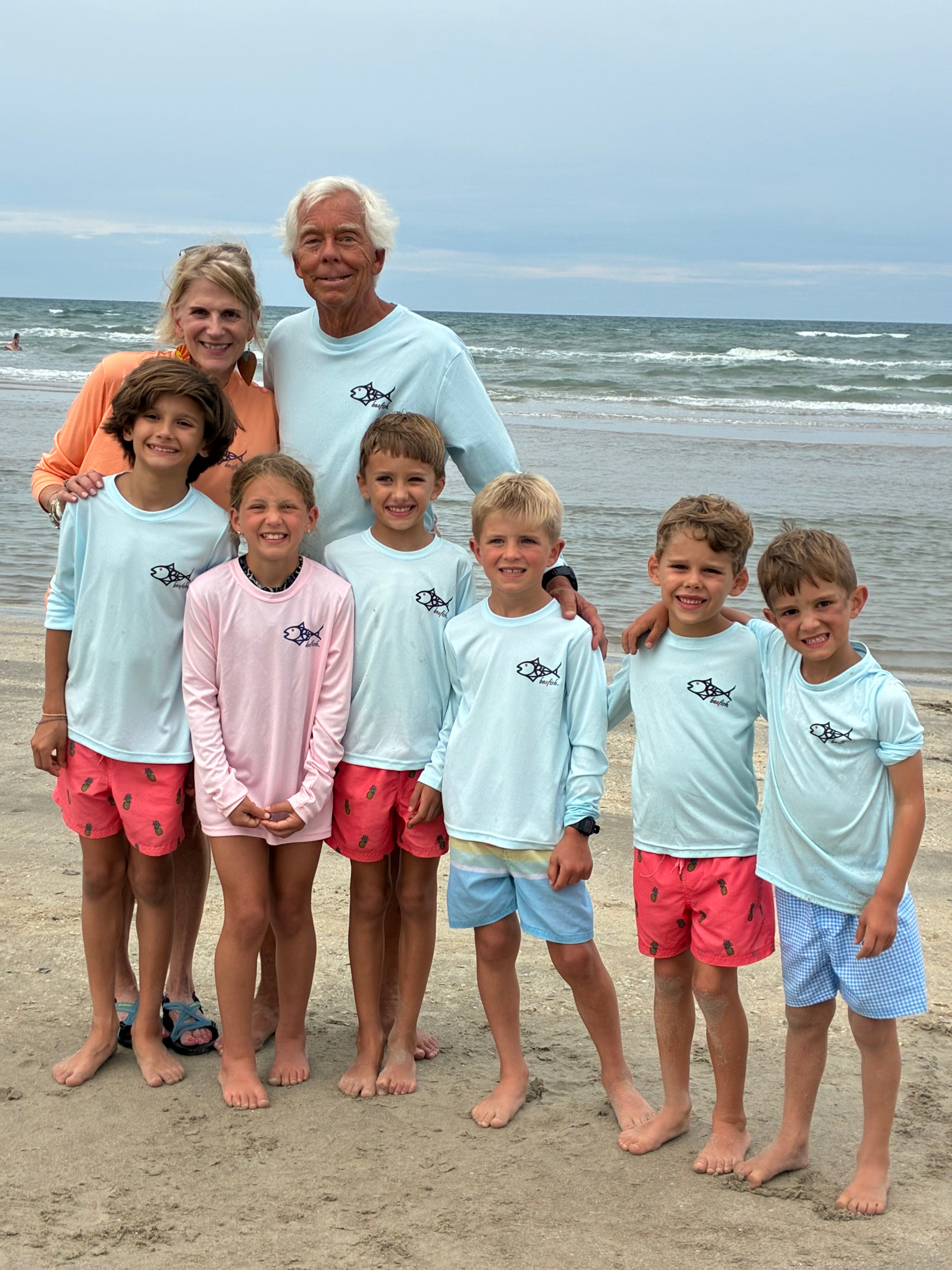 Family of eight posing together on a beach